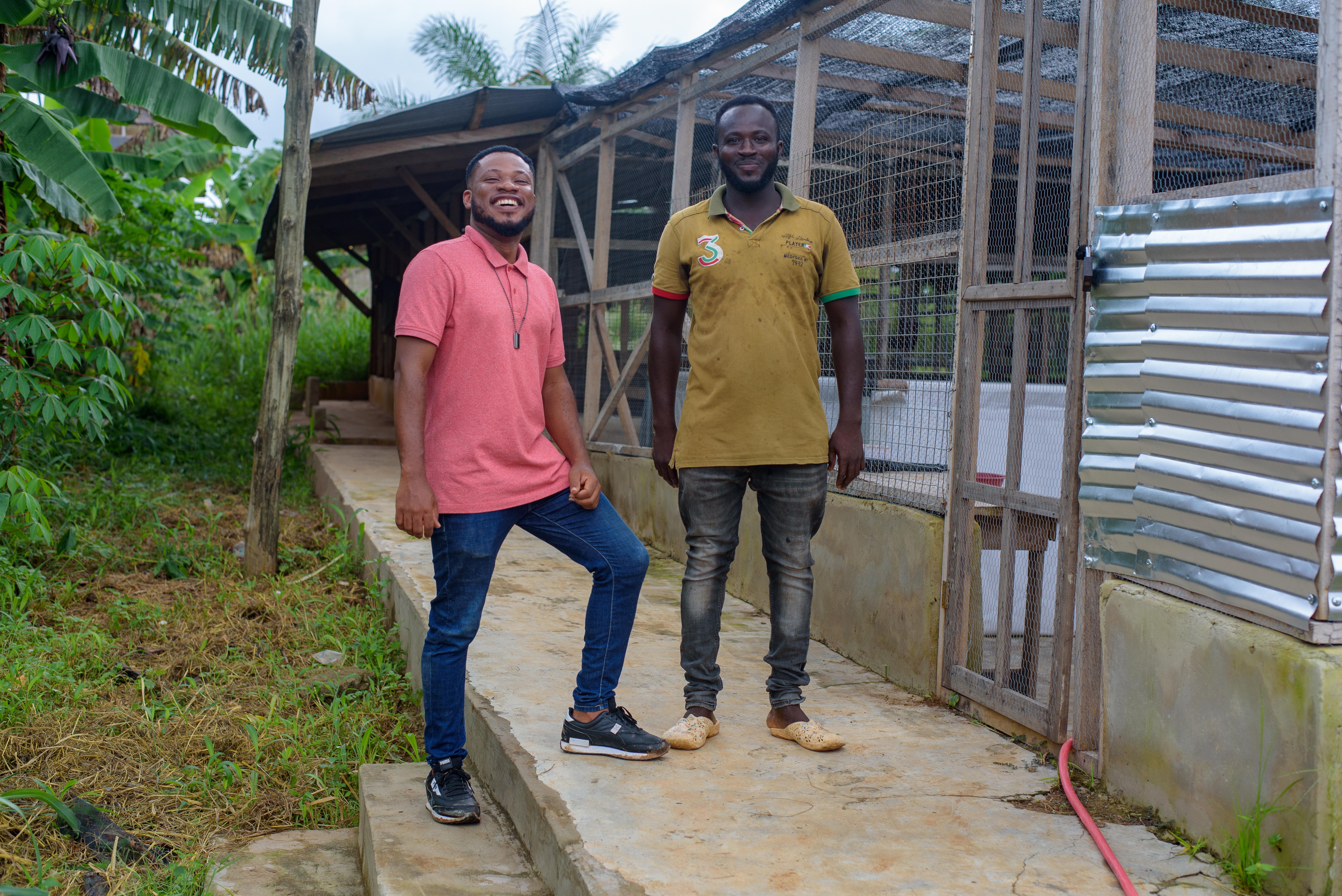 Kwasi Bame Anokye stands in front of his snail farm together with his employee