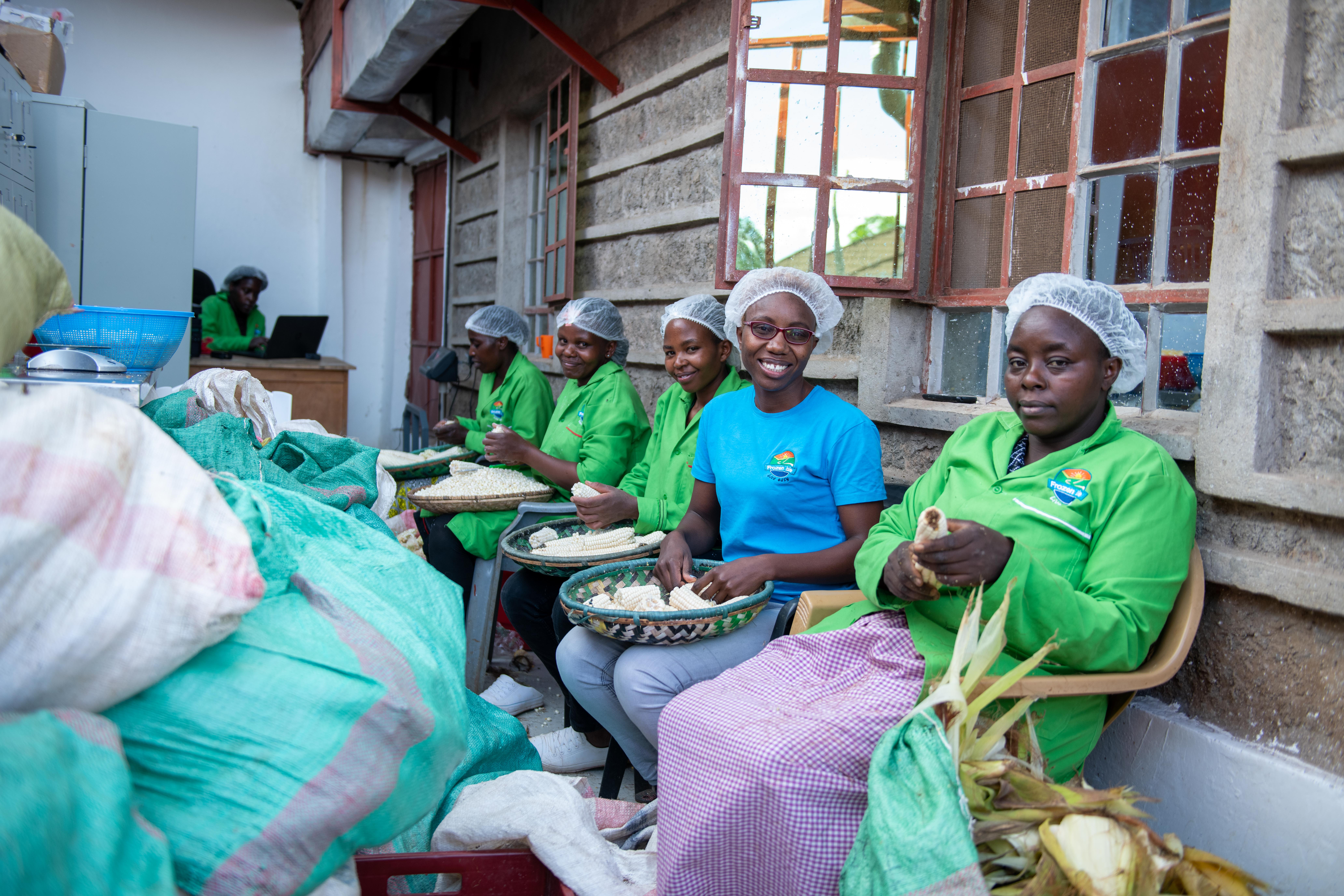 Florence and her team sit together and peel corncobs. Copyright: WIDU.africa