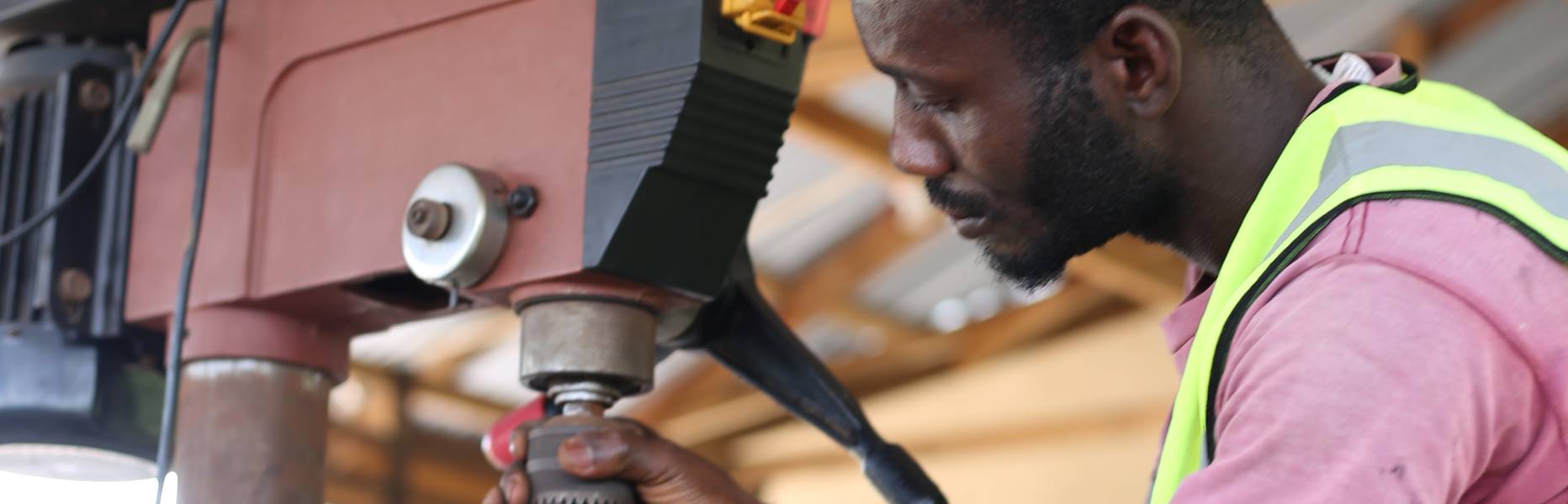 Stephen Orlando Mensah bedient eine Bohrer in seiner Werkstatt. 