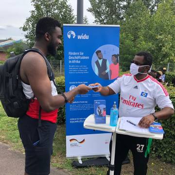 WIDU supporter hands over information flyer to interested participant