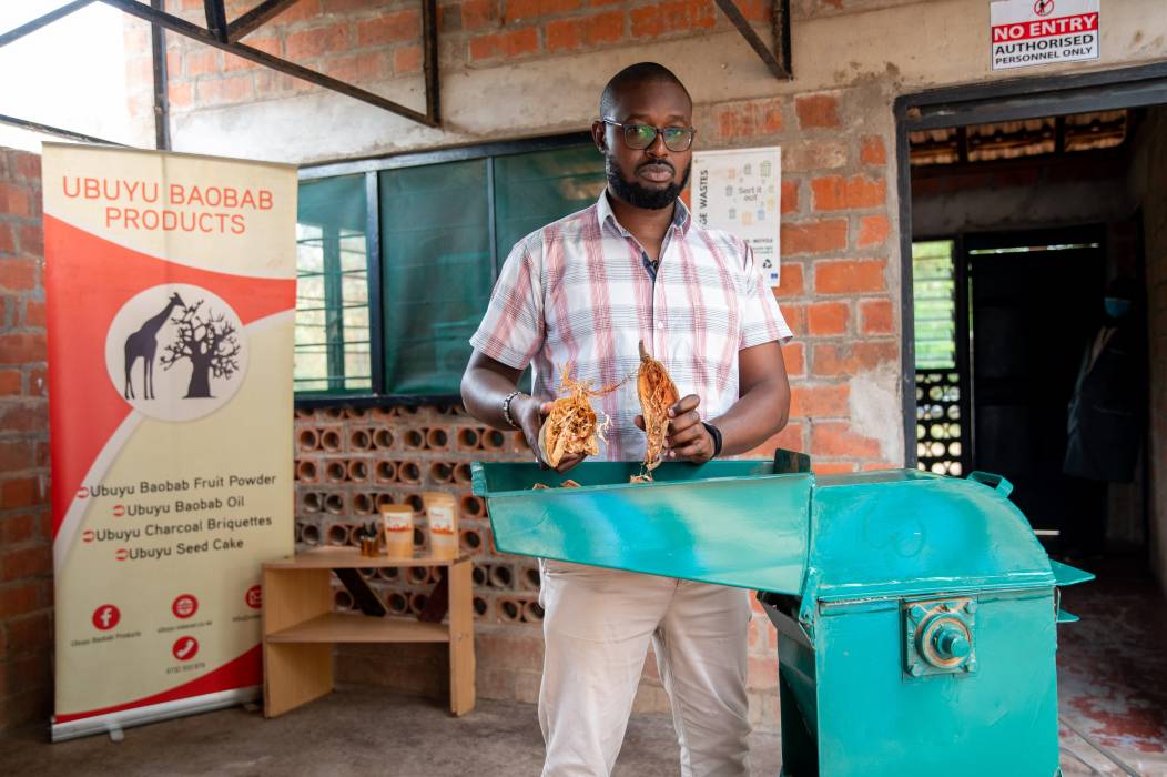 Kevin Kibuka, owner of the Kenyan business Boabab Husks Planting Media presents machine he purchased from his WIDU Grant