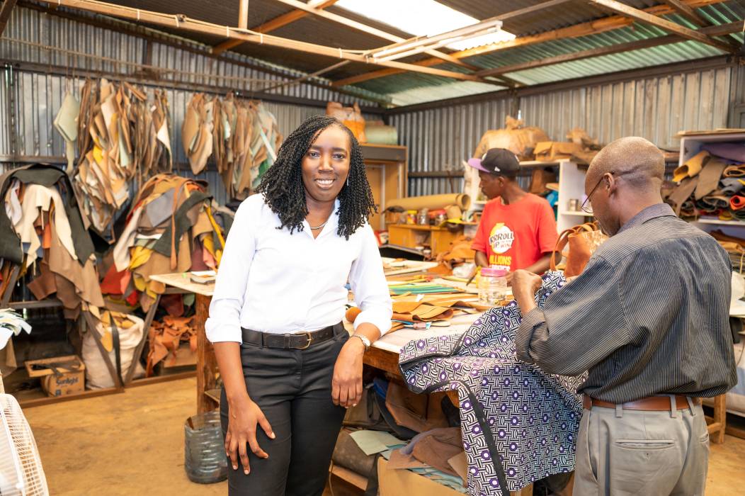 Owner of the Kenyan Business Pure Purple & WIDU Participant stands in the middle of her workshop and presents her bags