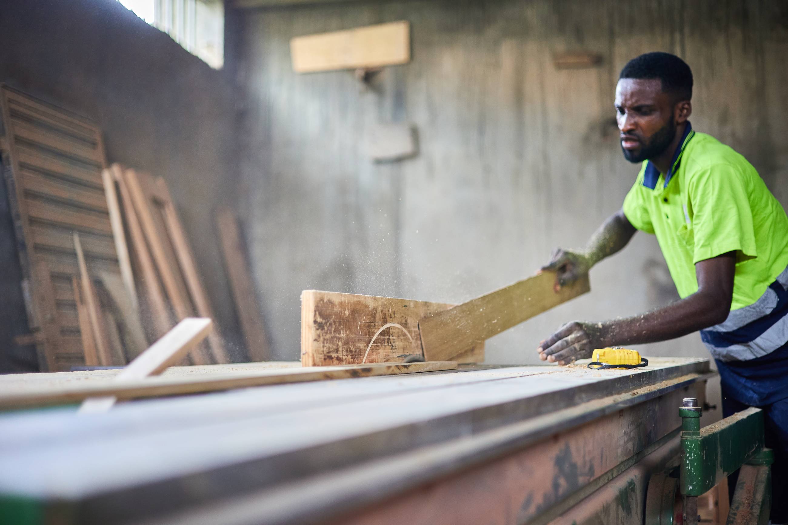 Young man cutting a piece of wood with a circular saw