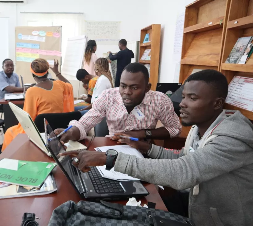 Entrepreneurs discussing in front of a Notebook at FANEPIA Office