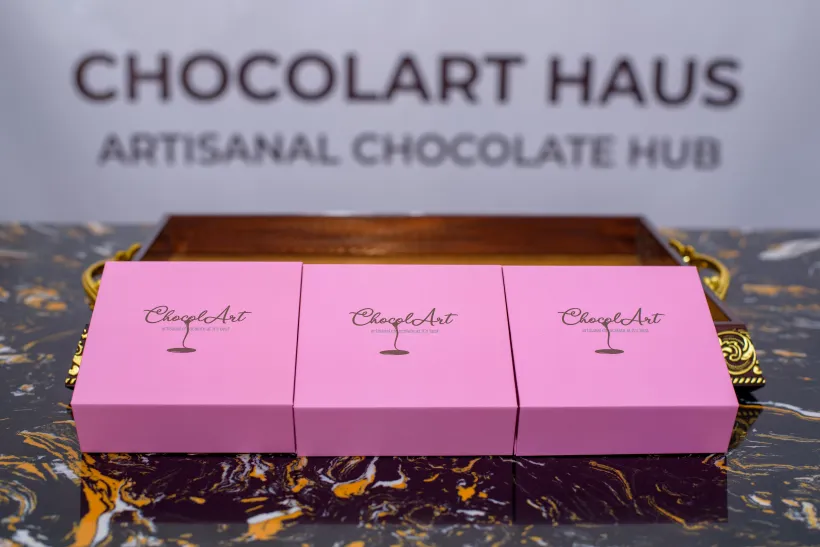Three pink gift boxes from ChocolArt Haus showcasing artisanal chocolate packaging.
